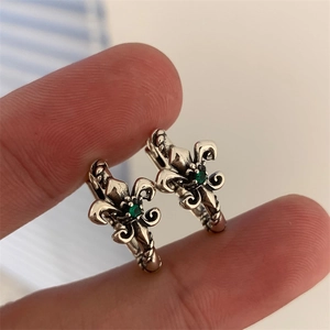 Makroaufnahme von Vintage-Silberohrringen mit Smaragd-Zirkon und Fleur-de-lis-Motiv