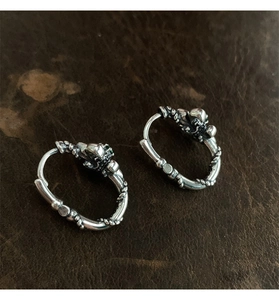 Details von Vintage-Silberohrringen mit Totenkopf-Design und smaragdgrünen Zirkonias