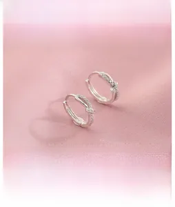 Close-up of silver twist knot hoop earrings with sparkling micro-pave cubic zirconia