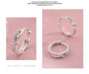 Detailed view of silver twist hoop earrings with pavé set shimmering cubic zirconia stones