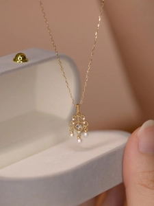 Détail macro du pendentif doré victorien avec pierre de lune et trois perles blanches