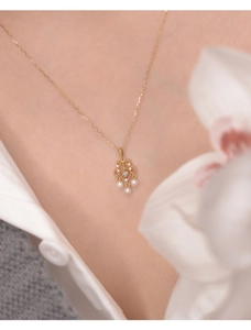 Gros plan d'un collier de perles vintage avec pendentif pierre de lune doré