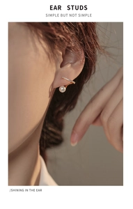 Gros plan de clips d'oreilles dorés en forme de C avec perles et zircons brillants