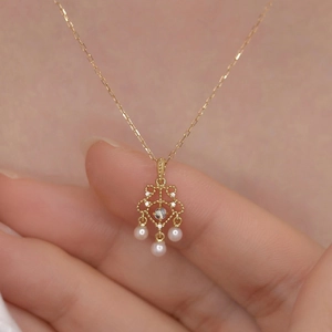 Collier vintage doré avec pendentif pierre de lune et perles sur une chaîne fine