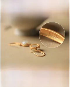 Macro-opname van het S925-keurmerk op vintage Hetian jade oorbellen met gouden plating