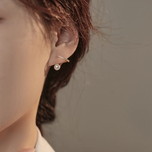 Élégante manchette d'oreille dorée avec perle et zircons portée par un mannequin