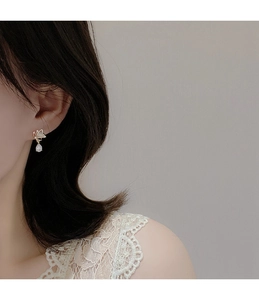 Detail of elegant gold butterfly earrings with opal stone drops on female model