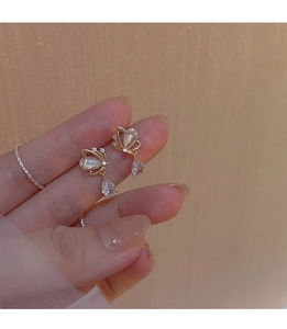 Detailed close-up of gold butterfly earrings with opal stone and teardrop zircon drop