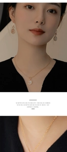 Détail du pendentif rond doré avec nacre incrustée et gaufrage d'épis de blé