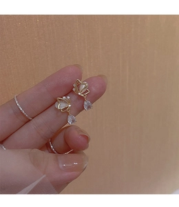 Close-up of golden butterfly earrings with cat eye stone wings and zircon droplets
