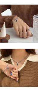 Detail of vintage silver chain bracelet with square blue zircon on female wrist