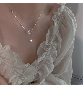 Dettaglio della collana con ciondolo luna satinata e stella indossata da modella