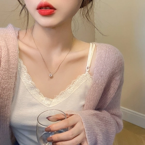 Gros plan d'un collier en zircon rose avec chaîne en argent porté sur le décolleté d'un mannequin