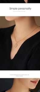 Détail du collier à fermoir OT doré avec pendentif ovale en relief sur le modèle