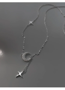 Dettaglio della collana d'argento con luna crescente in cristallo e ciondoli a stella