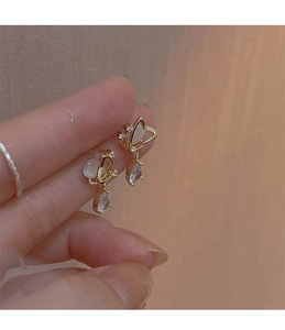 Macro shot of butterfly earrings with opal texture and teardrop crystal pendants
