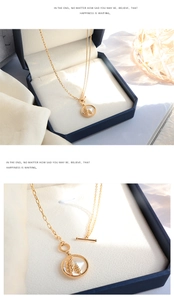 Détail du collier doré avec pendentif en nacre et fermoir à bascule en T chic