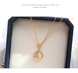 Détail du collier doré avec pendentif rond en nacre et fermoir à bascule OT élégant