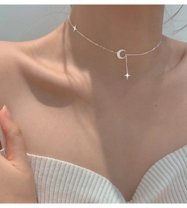 Dettaglio ravvicinato della collana in argento opaco con luna e stella indossata