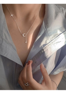 Dettaglio della collana luna satinata con ciondoli a stella indossata da modella