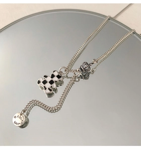 Detail of S925 silver necklace with checkerboard bear, crown and Lucky Star tag