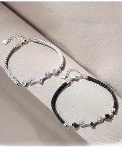 Close-up of black and white woven couple bracelets with crystal deer antler charms