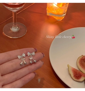 Detailed macro view of cherry bow earrings with sparkling rhinestones and silver finish