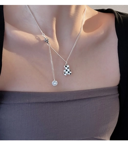 Detailed shot of the S925 silver bear necklace featuring a black and white checkerboard pendant