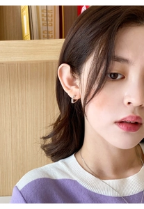 Gros plan de boucles d'oreilles cœur élégantes portées avec un collier argenté