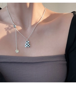 Detail of bear pendant with checkered pattern and Lucky Star engraved metal tag