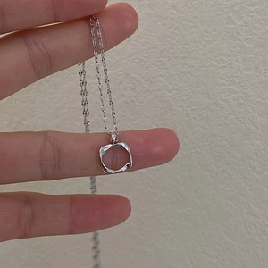 Minimalist silver-tone necklace with twisted hollow square pendant on a delicate chain