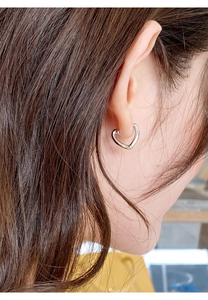 Gros plan sur des boucles d'oreilles cœur argentées portées par un mannequin en gros plan