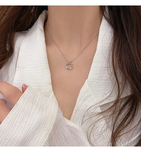 Close-up of minimalist silver hollow square pendant necklace worn with white shirt