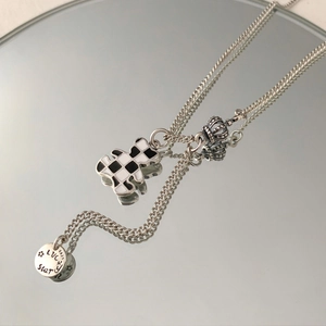 S925 silver necklace with black and white checkered bear and crown charms on mirror