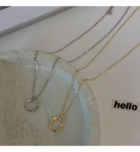 Detailed close-up of minimalist square cutout pendants in gold and silver finishes