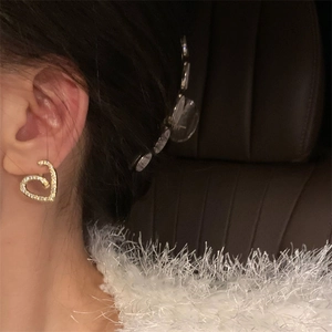 Gros plan de boucles d'oreilles cœur étincelantes avec zircons portées par un modèle