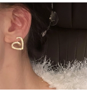 Gros plan de boucles d'oreilles cœur scintillantes avec zircone sur un mannequin élégant
