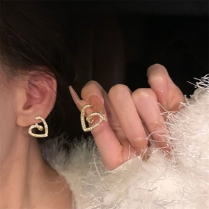 Gros plan sur des boucles d'oreilles cœur dorées avec zircons pour un look chic