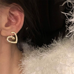 Gros plan de boucles d'oreilles spirale en cœur avec zircons et finition dorée