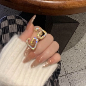 Bague cœur élégante dorée sertie de zircons brillants portée à la main style minimaliste