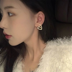 Vue latérale macro d'un clou d'oreille coeur doré avec zircons sur un mannequin