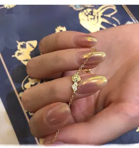 Détail d'un bracelet rose doré avec strass blancs sur une fine chaîne délicate