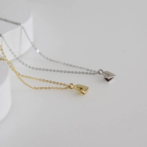 Detailaufnahme des 3D-Herzanhängers in poliertem Gold und Silber für Damen