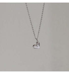 Detailansicht einer silbernen Kette mit geometrischem Herzanhänger im schlichten Design
