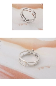 Detail view of silver double-layered ring featuring hollow letter D and star charms