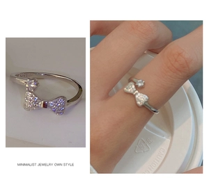 Detail showing S925 silver hallmark and crystal bow ring worn on human finger