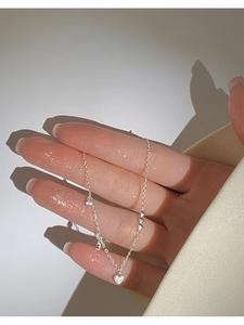 Detalle de la pulsera de corazón plateada con circonitas rectangulares en cadena fina