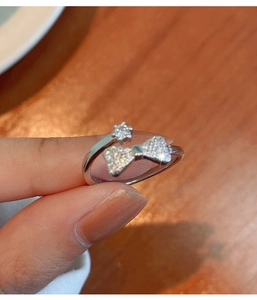 Close-up of sparkling bow and star ring showing the S925 silver hallmark engraving