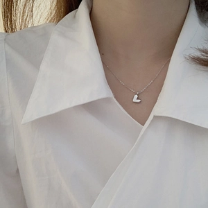 Minimalistische silberne Herz-Halskette mit geometrischem Anhänger an einem Model