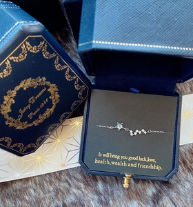 Détail d'un bracelet chat en argent avec pierre de lune et zircons dans un écrin cadeau